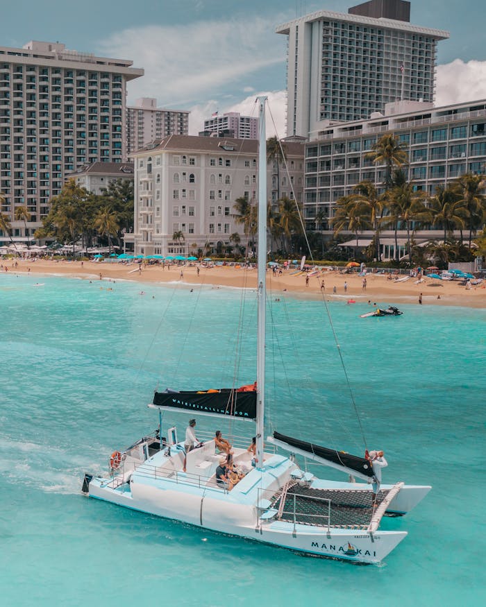 why-choose-us Scenic view of catamaran sailing near hotels on Waikiki Beach, Honolulu, Hawaii.